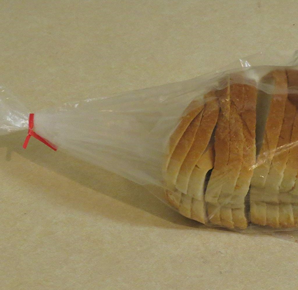 Loaf of bread inside a Decony Plastic Bread Bag on countertop.
