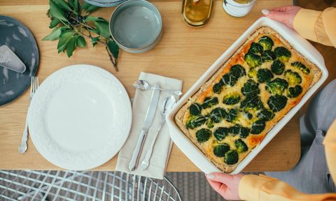 best casserole carriers overhead view of woman holding broccoli while standing at dining table