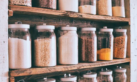 organization tricks to make pantry feel bigger jars of ingredients on wooden shelves