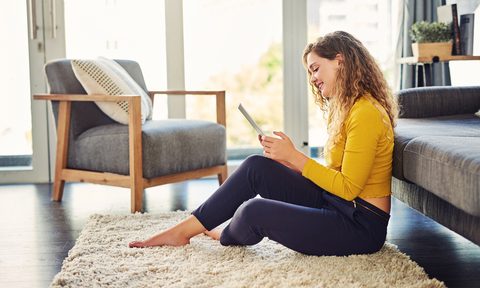 Woman sitting on living room floor area rug