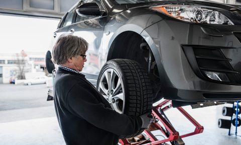 the best car lifts for your garage mechanic adjusting tire on at workshop