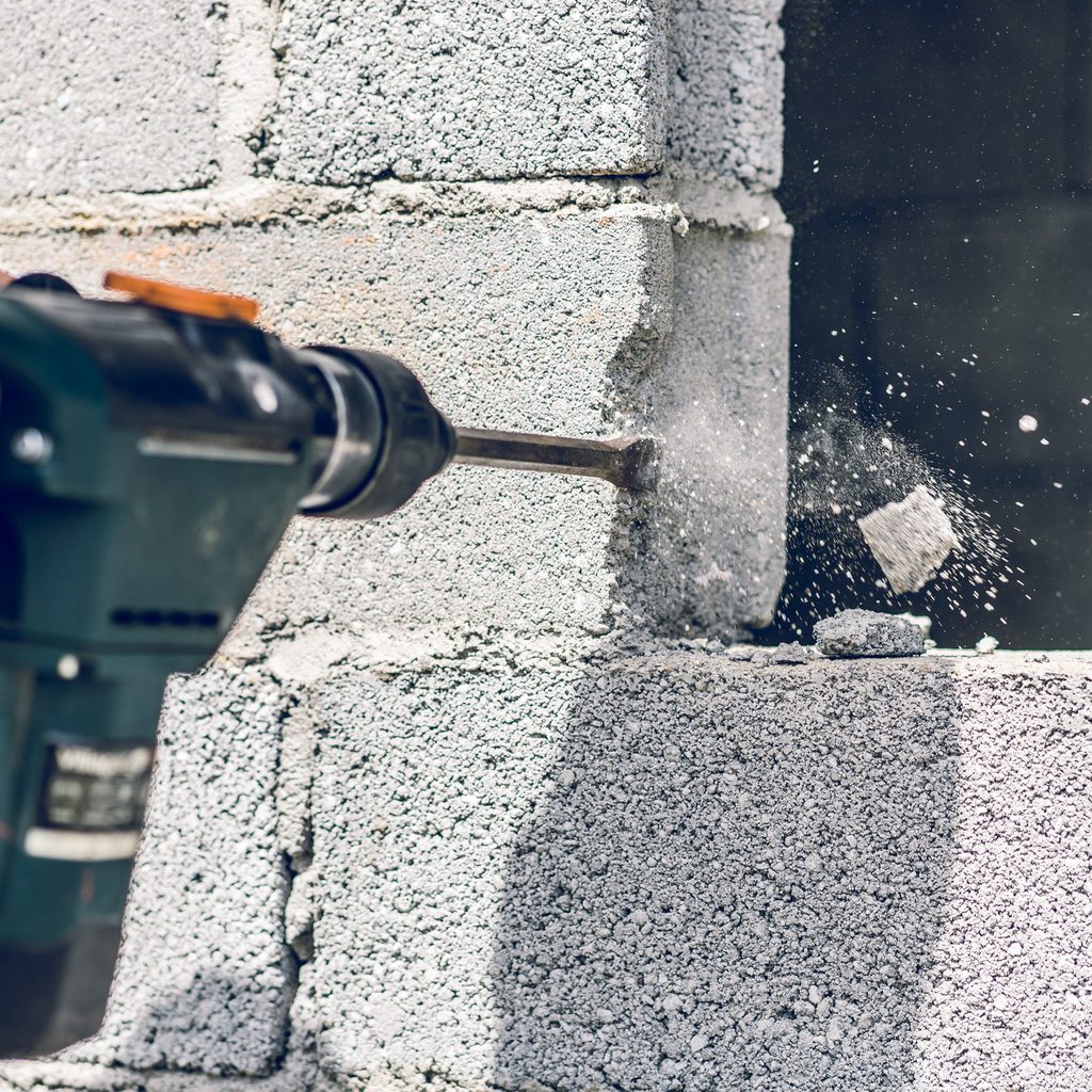 Person drilling into brick
