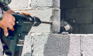 Person drilling into brick