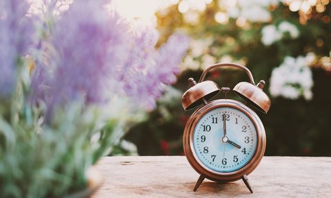 Alarm clock on a table with flowers