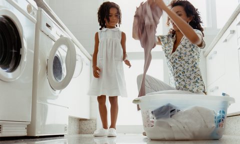 Mom and child placing laundry into a front loading washing machine