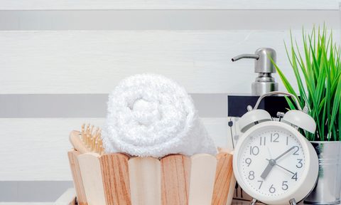 Clean towel in wooden bucket on wooden shelf