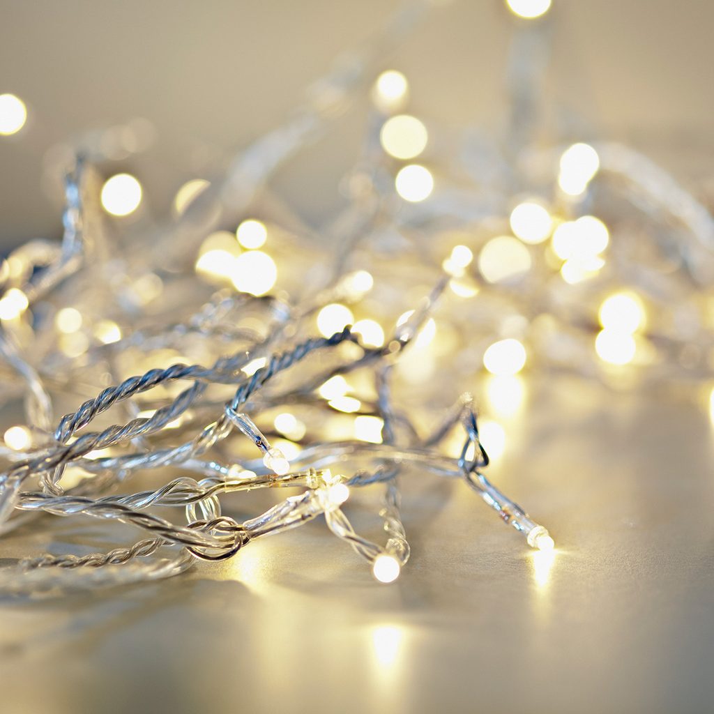 String of tangled fairy lights on a gray reflective surface