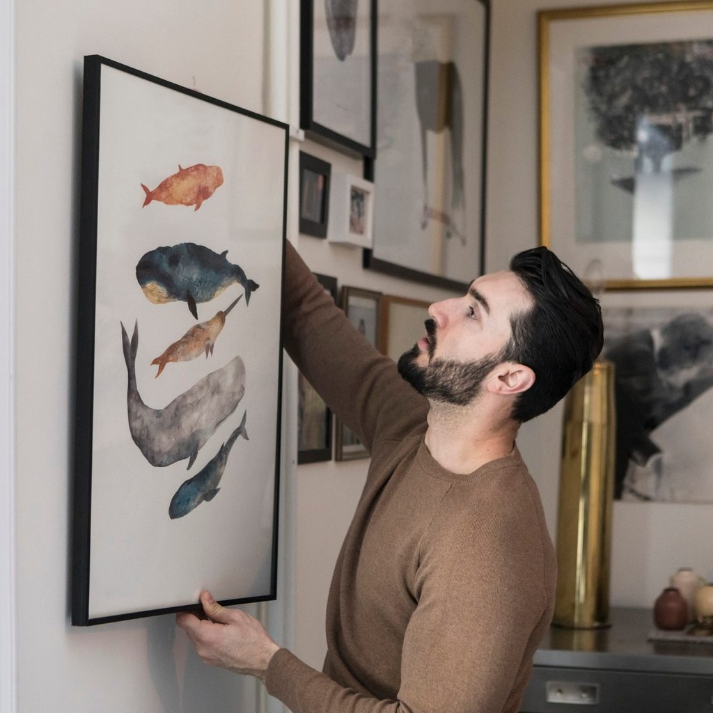 man hanging framed wall art