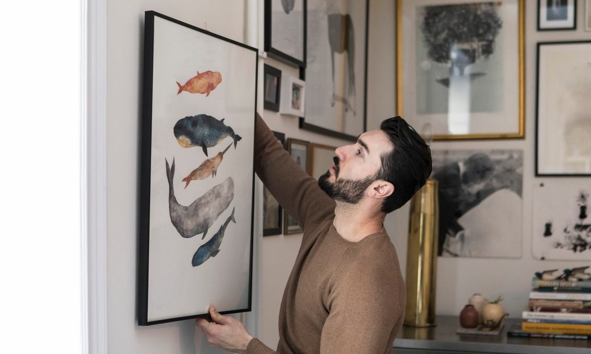 man hanging framed wall art