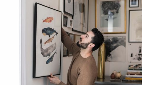 man hanging framed wall art