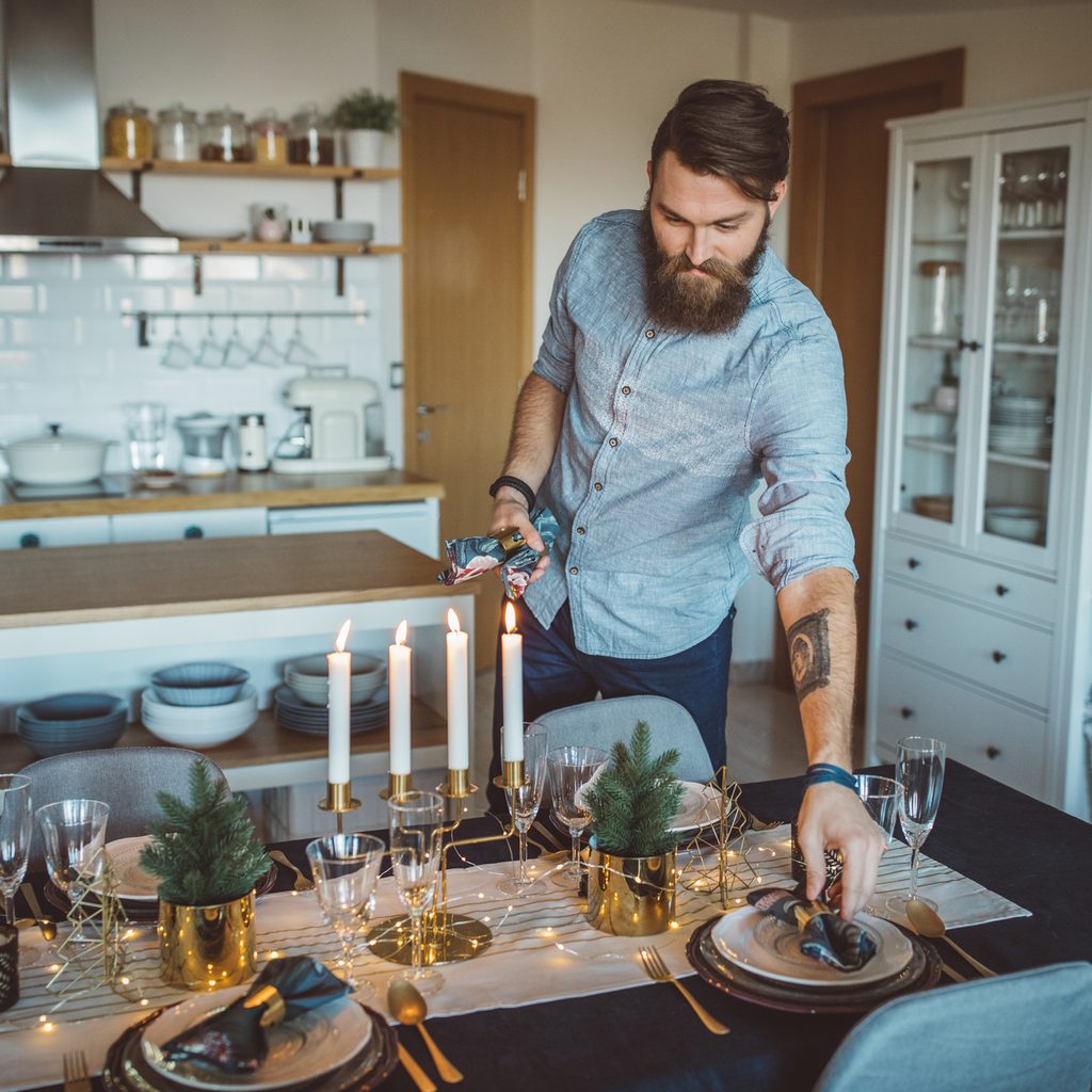Man setting an elegant table for a holiday dinner