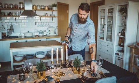 Man setting an elegant table for a holiday dinner