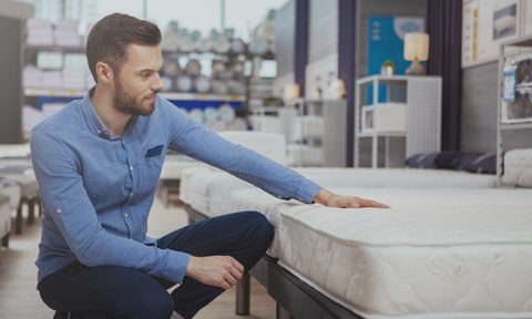 how to choose the right mattress handsome man shopping at furnishings store