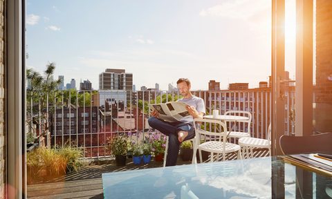 Reading the paper on an apartment deck