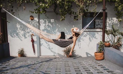 Woman swinging in a hammock on a patio