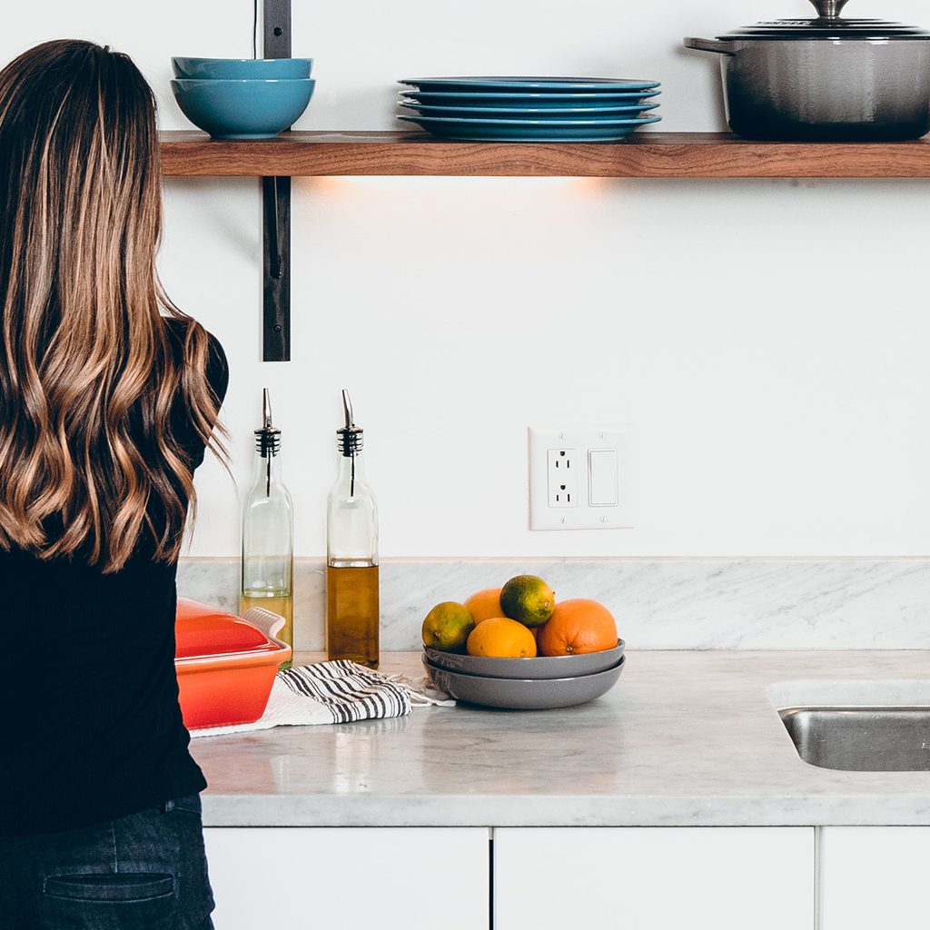 Women Placing Flowers on Kitchen Countertop