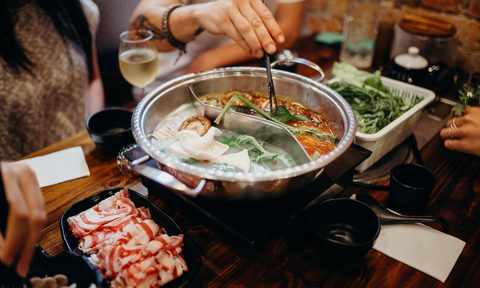 best hot pots korean pot meal  hands taking food with chopsticks