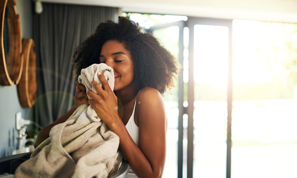 Woman smelling clean towel