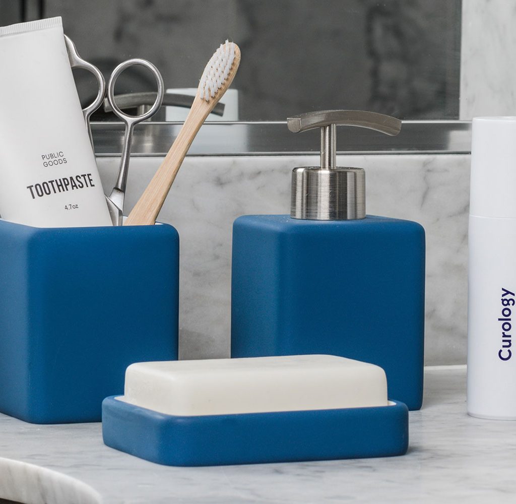 A clean bathroom sink with stored items
