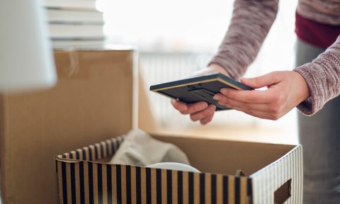 the best photo storage boxes close up of woman unpacking cardboard box in new home