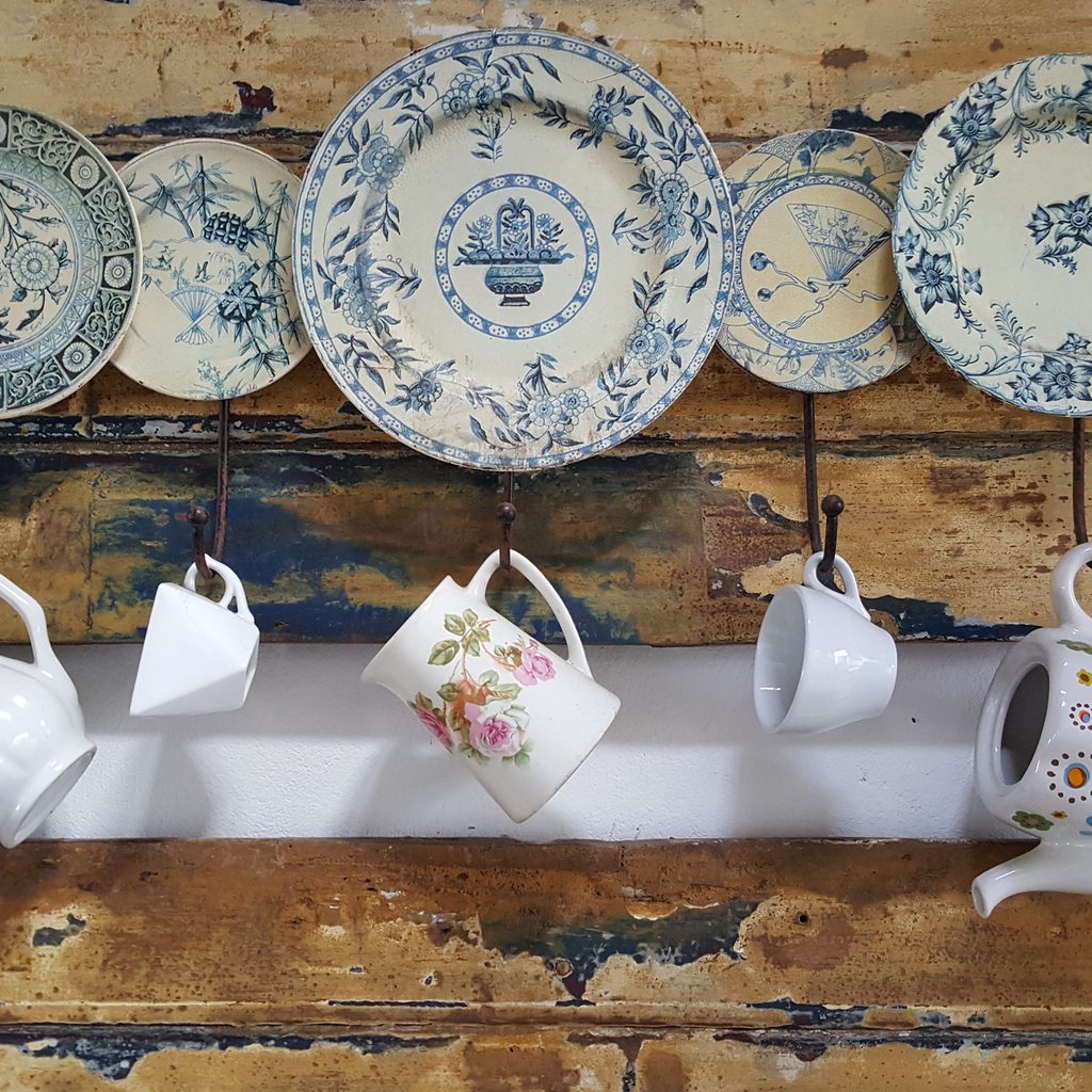 Cups and plate hanging on a wooden wall In the kitchen