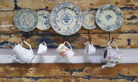 Cups and plate hanging on a wooden wall In the kitchen