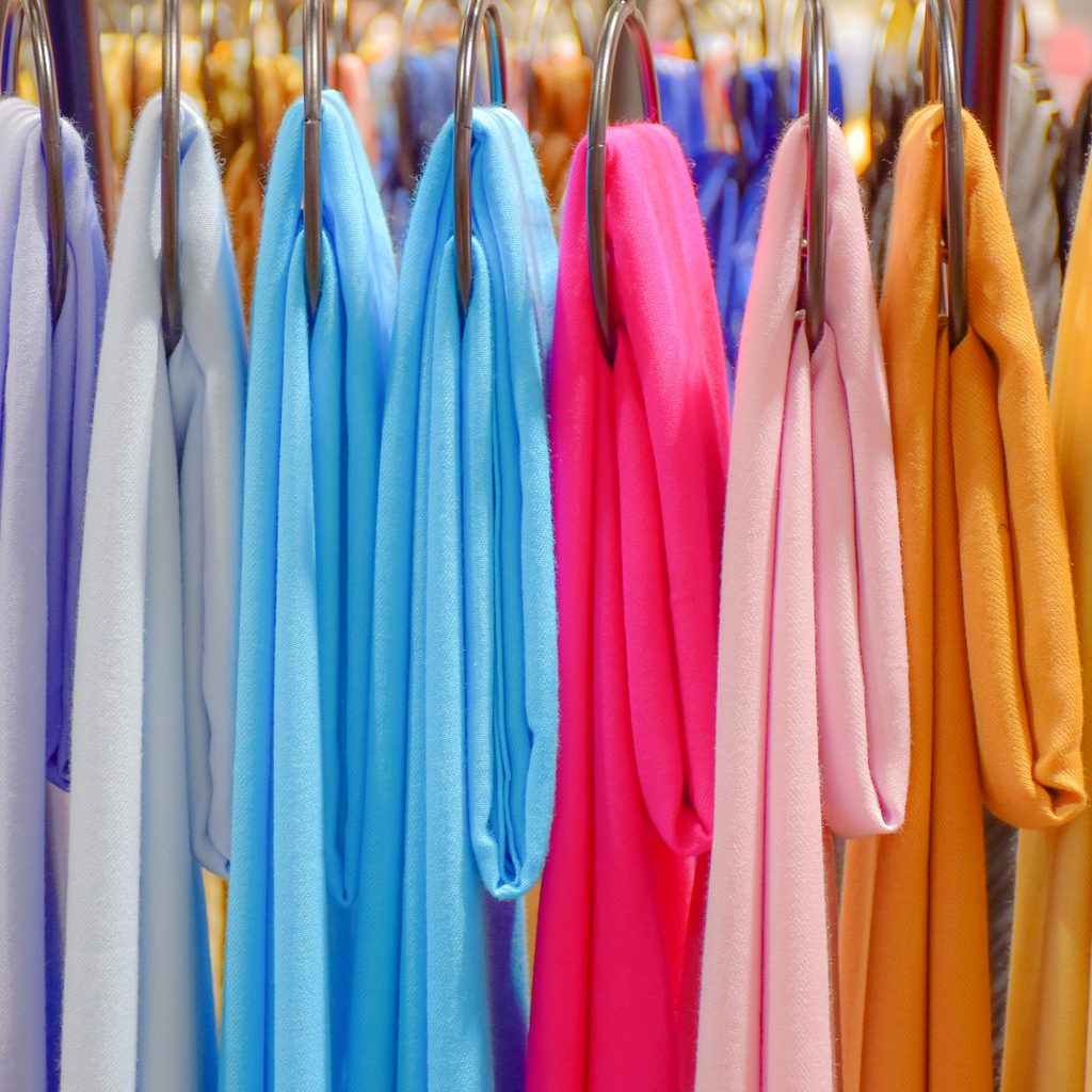 Multicolored scarfs hanging on rack in store