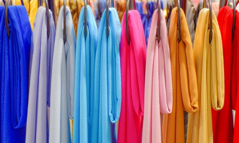 Multicolored scarfs hanging on rack in store