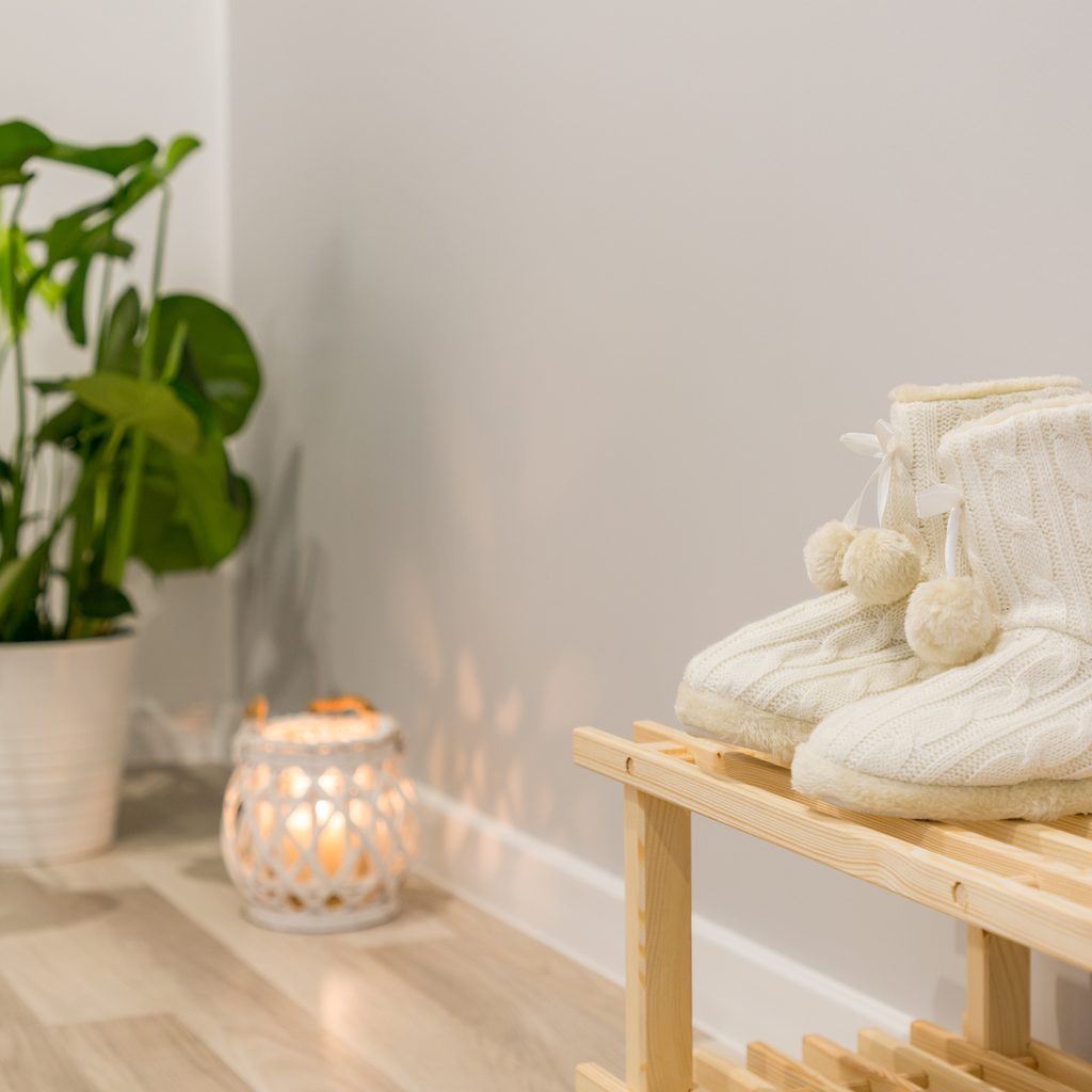 shoe rack bench near plant and candle