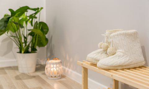 shoe rack bench near plant and candle
