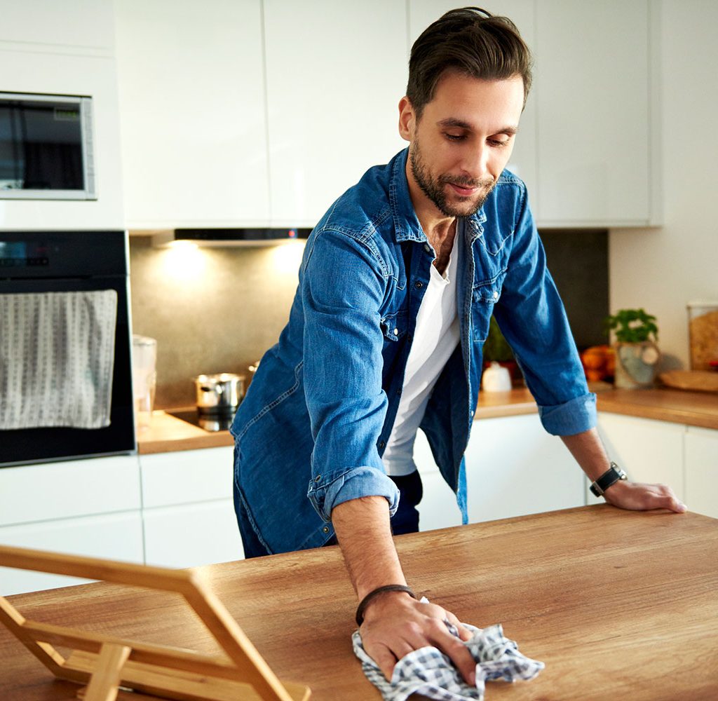Man cleaning kitchen counter