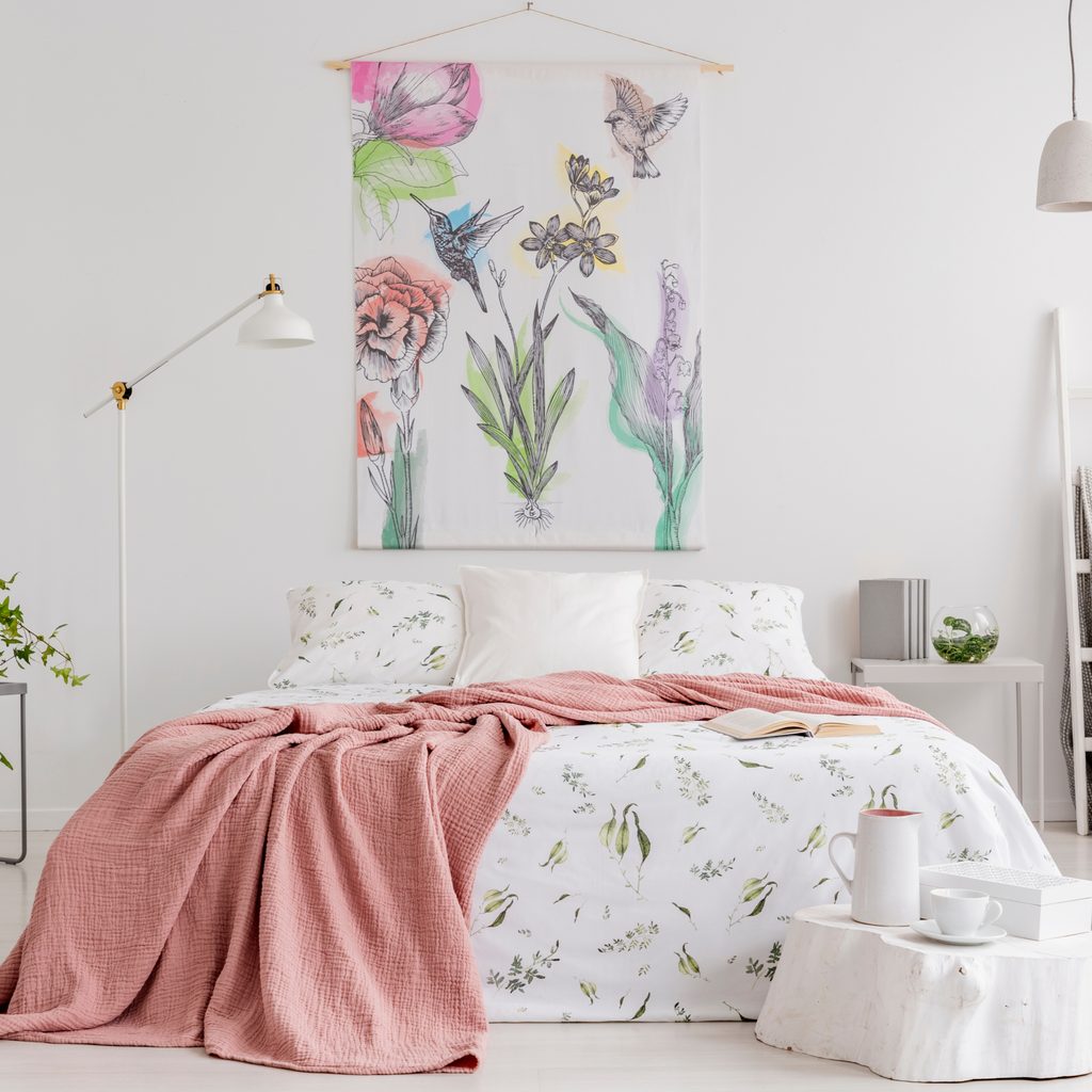 Simple flower tapestry hung above bed