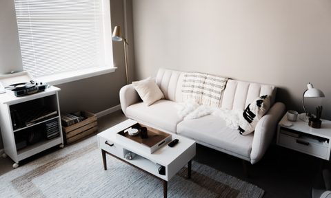 Neat living room with sofa, rug, coffee table, and small record player