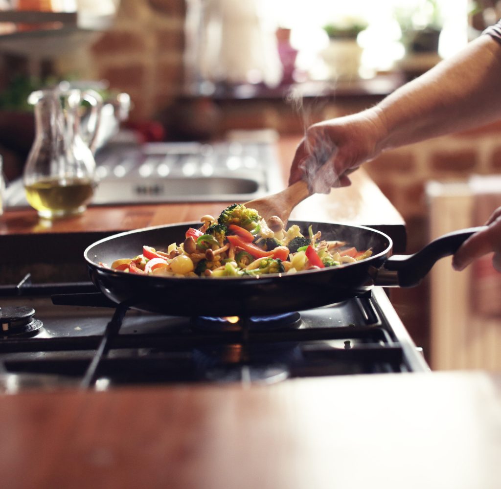person cooking stir fry