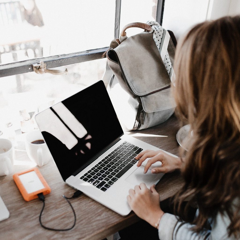 Woman working at home near window with laptop computer