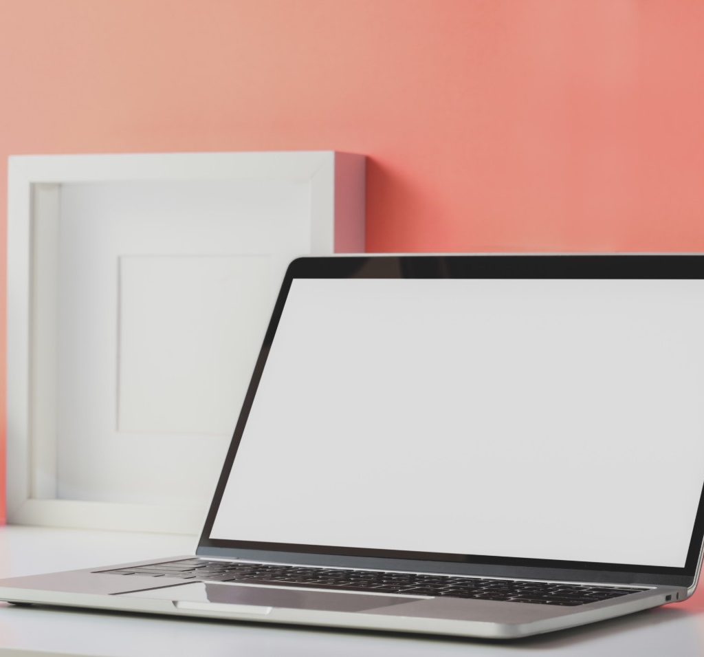 Laptop on desk with orange wall
