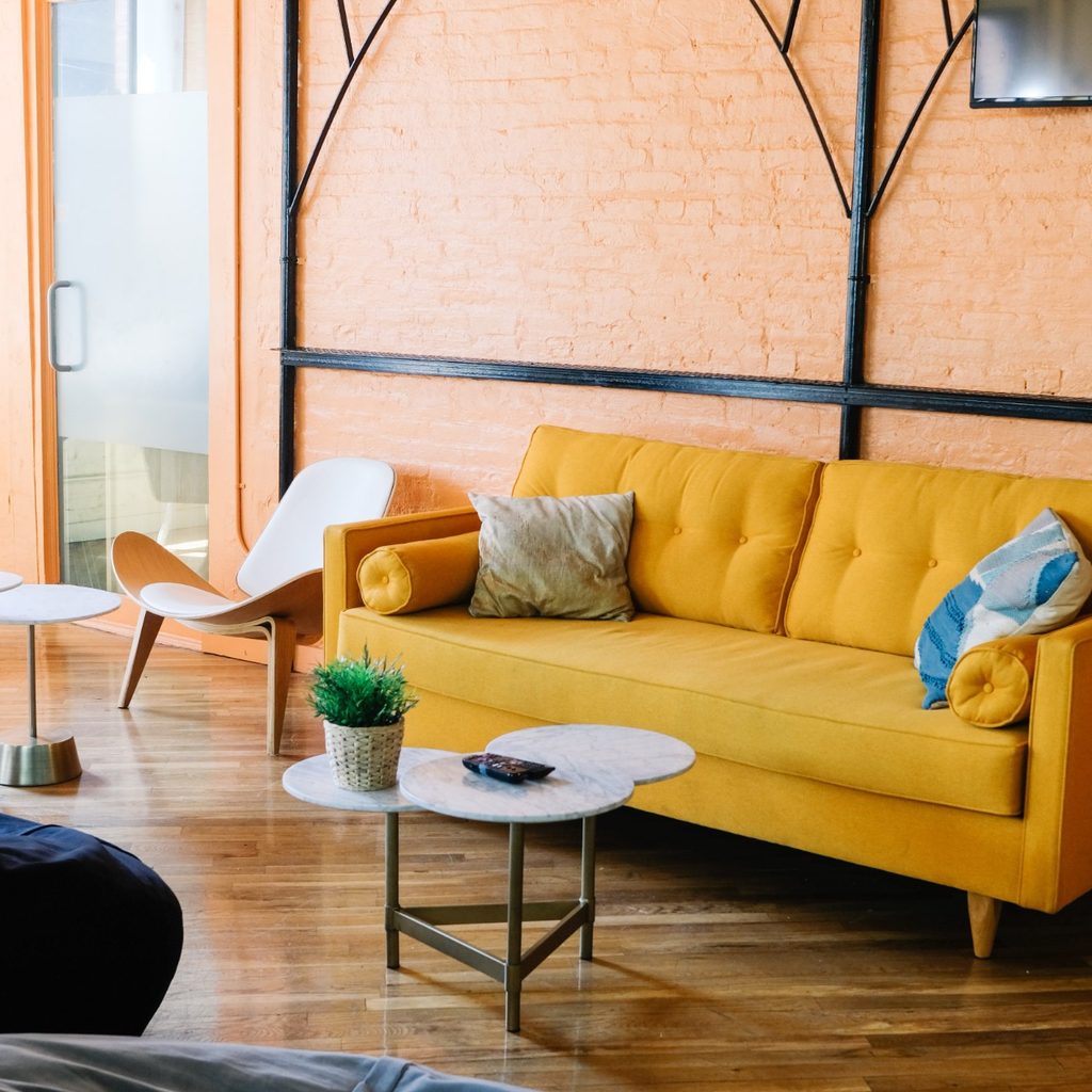 Living room with orange wall and yellow sofa