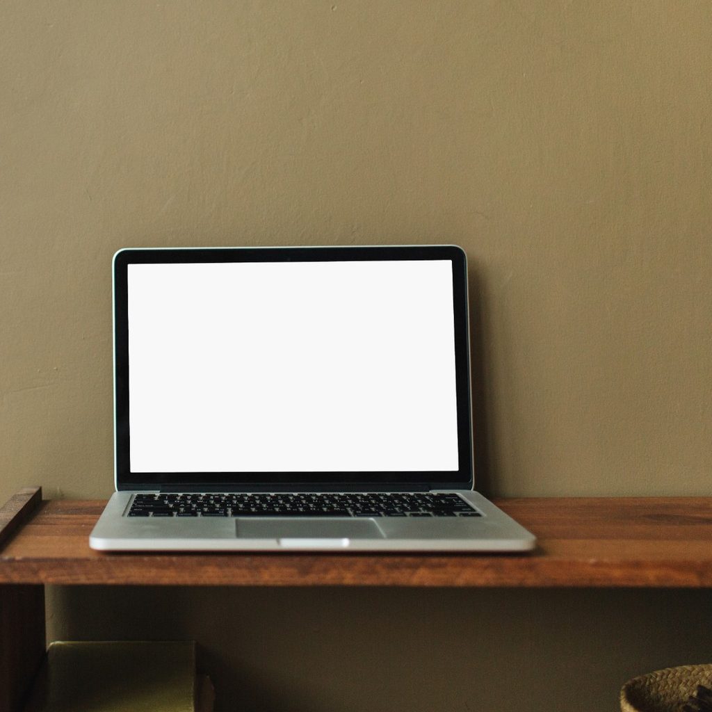 Laptop on desk with green wall