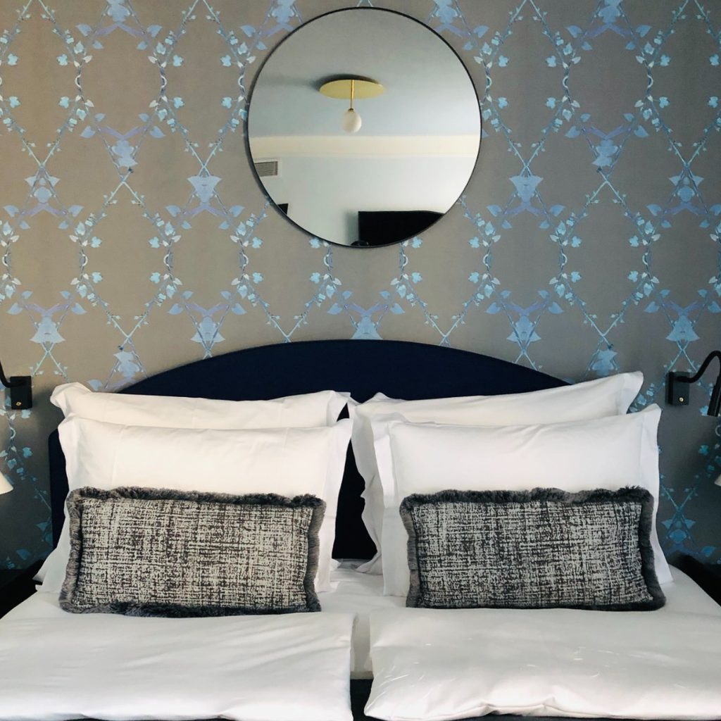 Bedroom with mirror and artistic wallpaper