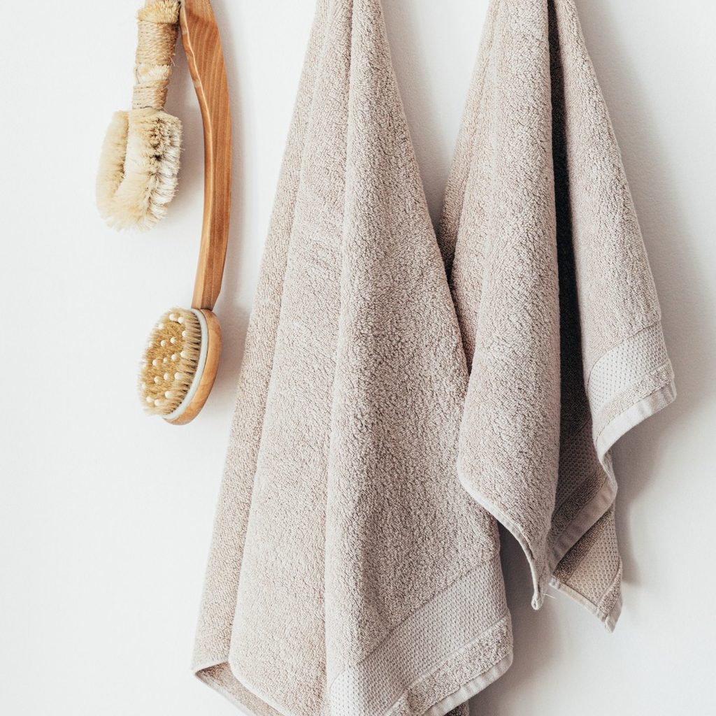 Two bathroom towels hanging on hooks