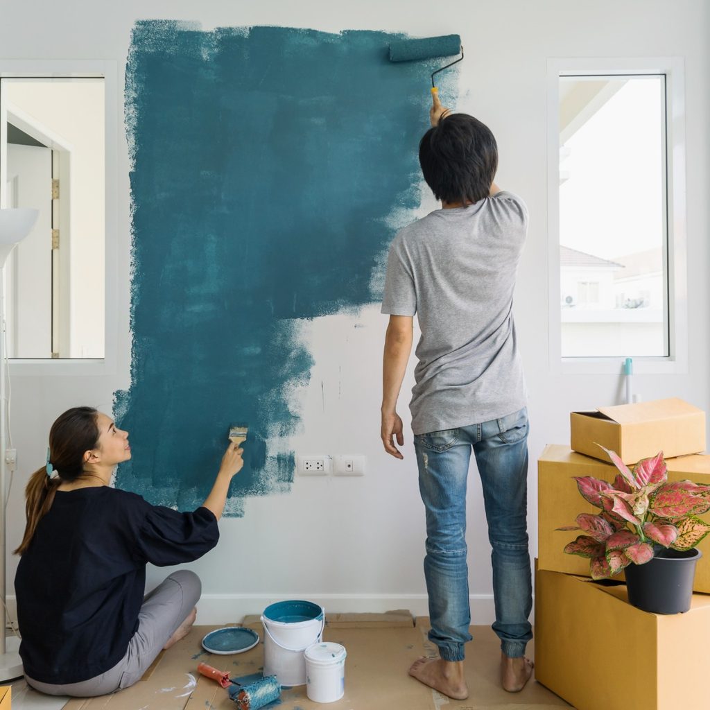 Wife and husband painting a wall