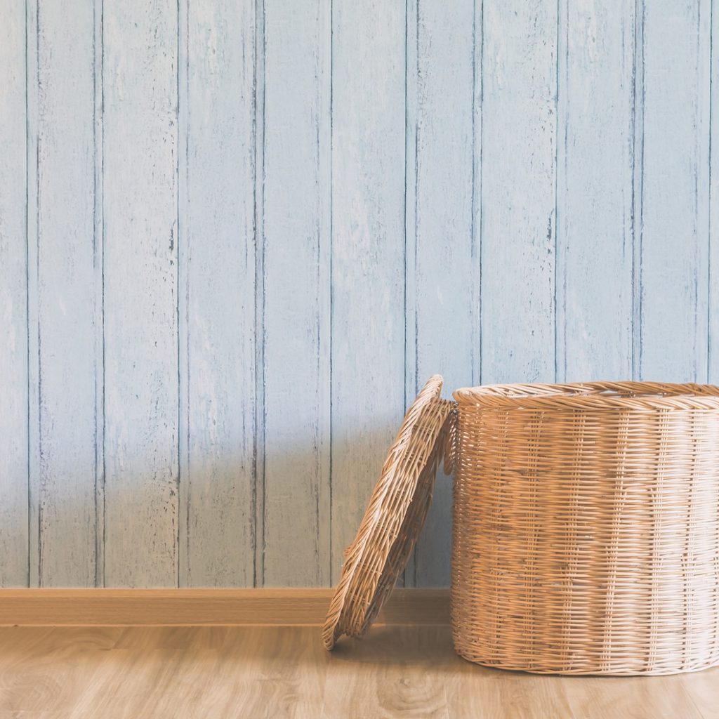 Wicker basket on floor with blue wall