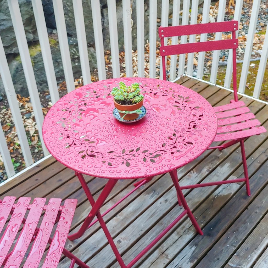 Two metal chairs with small metal table