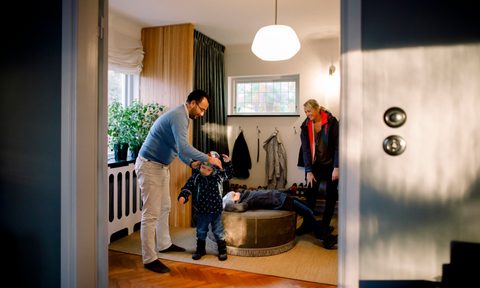 Mother and father putting coats on children