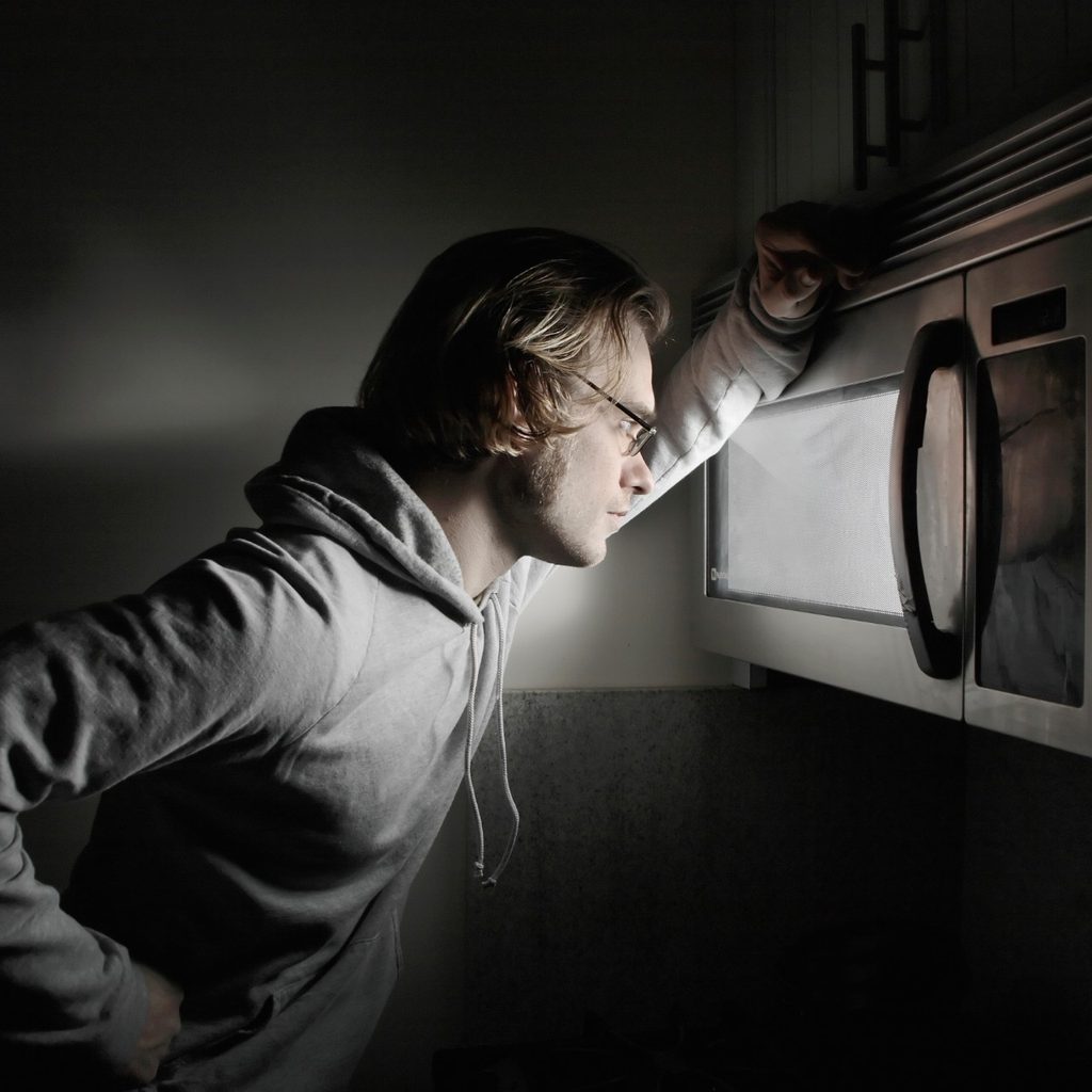 Man looking into microwave oven