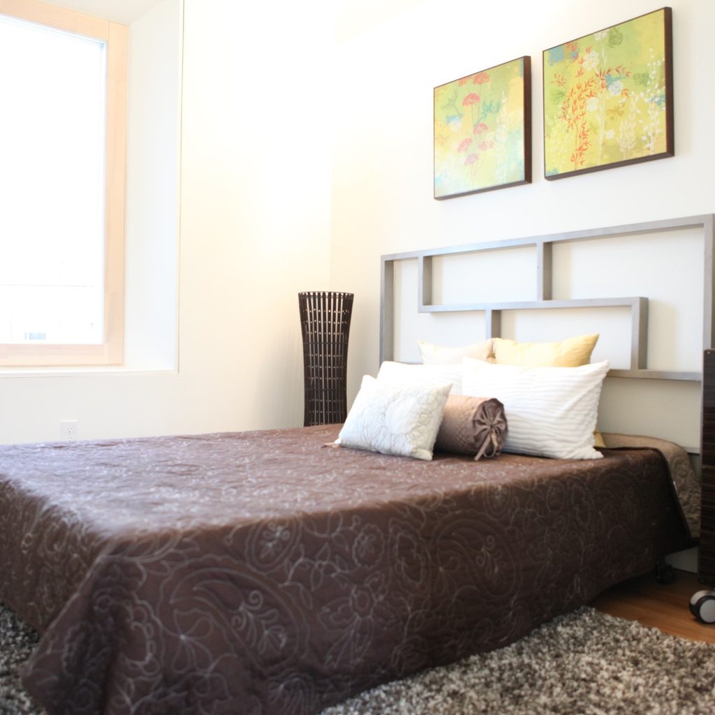 Artwork, headboard, and nightstand in bedroom