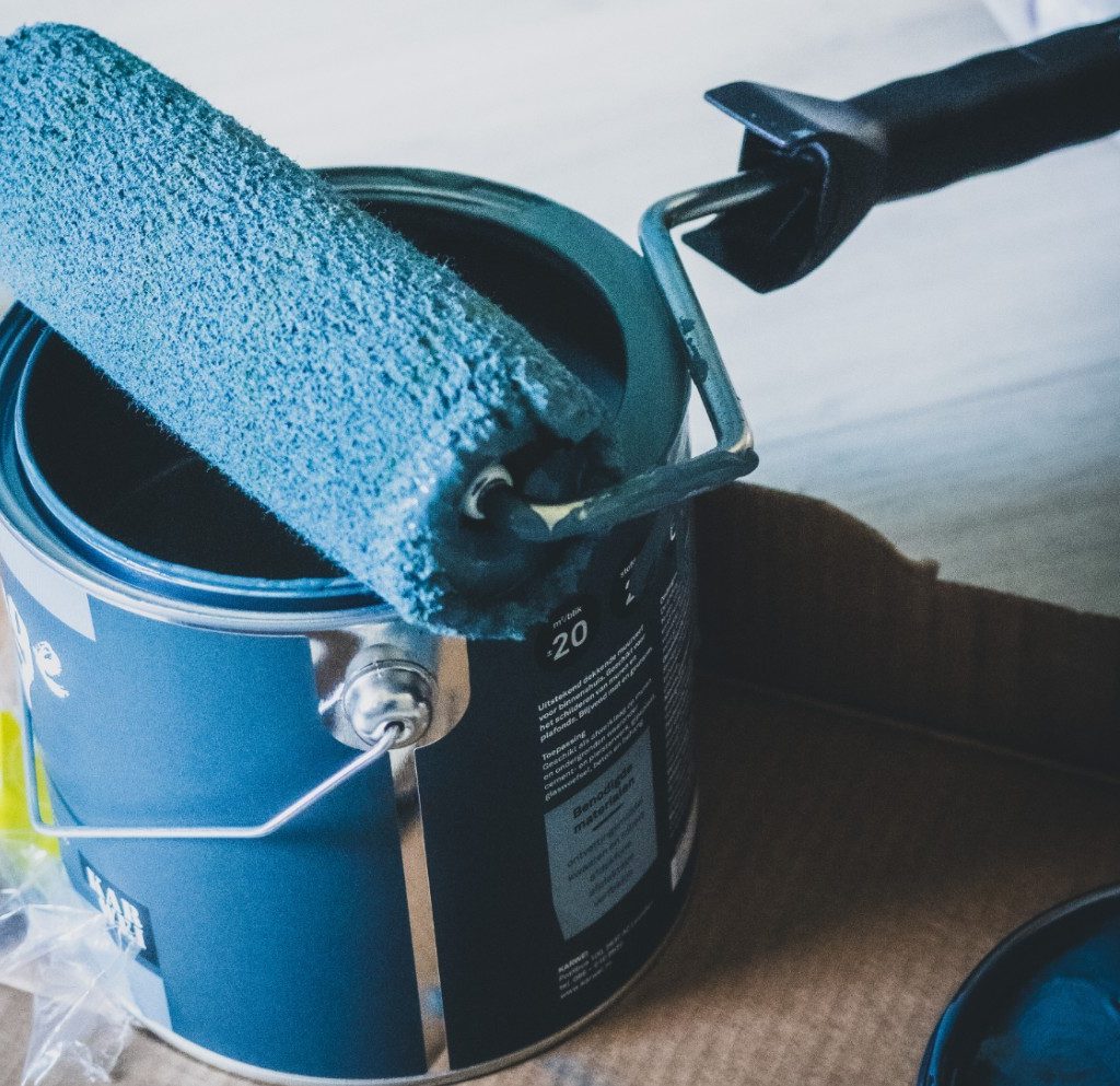 Paint roller with paint can on floor