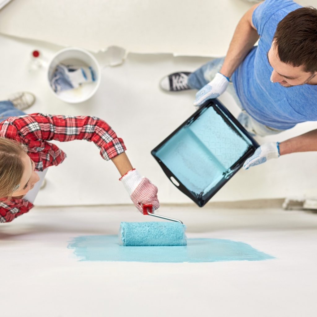 Woman and man painting a wall