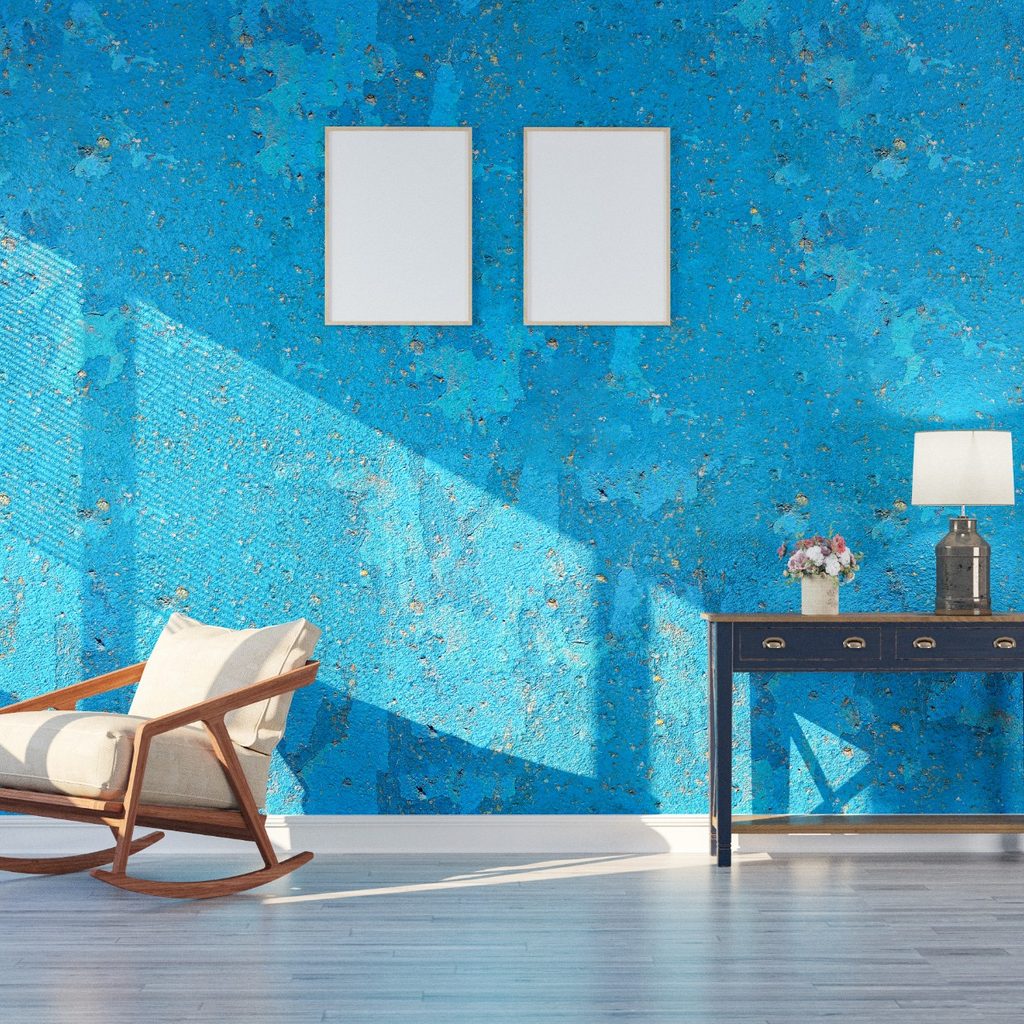 Sunny living room with blue wall, chair, and desk