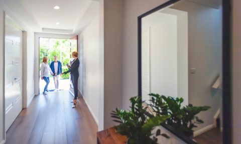 Woman welcoming friends at the front door